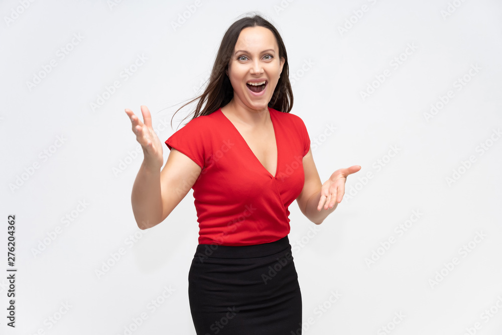 Portrait to the waist of a young pretty brunette woman of 30 years old in a bright red sweater with beautiful dark hair. Standing on a white background, talking, showing hands, with emotions Portrait to the waist of a young pretty brunette woman of 30 years old in a bright red sweater with beautiful dark hair. Standing on a white background, talking, showing hands, with emotions
