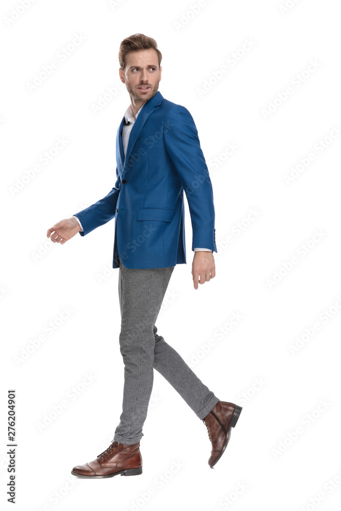 Concerned casual man looking over his shoulder and walking Concerned casual man looking over his shoulder and walking