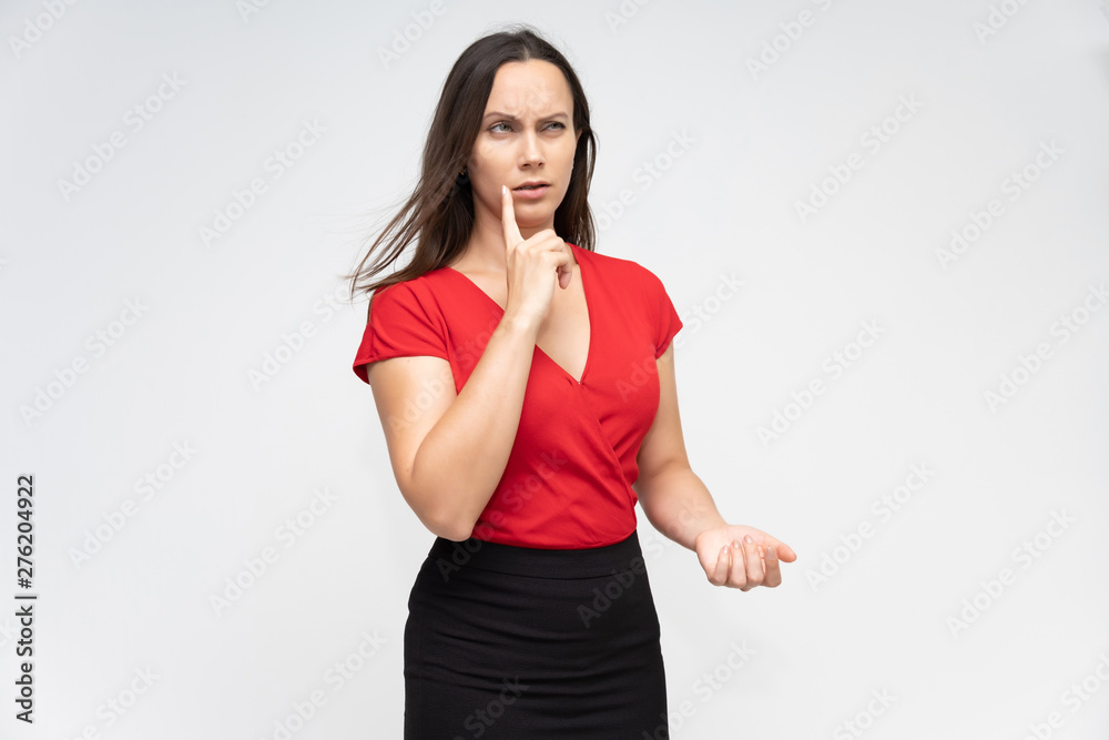 Portrait to the waist of a young pretty brunette woman of 30 years old in a bright red sweater with beautiful dark hair. Standing on a white background, talking, showing hands, with emotions Portrait to the waist of a young pretty brunette woman of 30 years old in a bright red sweater with beautiful dark hair. Standing on a white background, talking, showing hands, with emotions