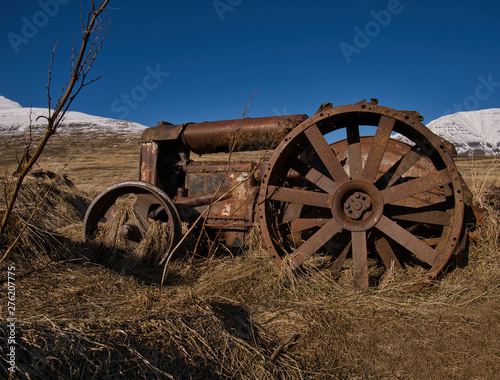 Ein alter verrosteter Traktor auf einer Wiese photo