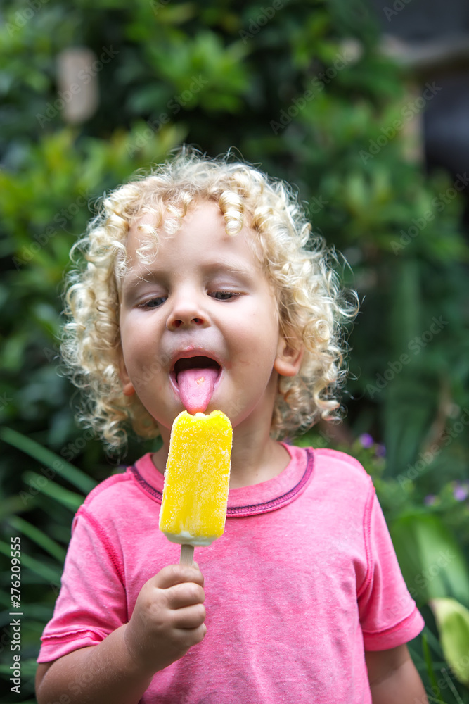 little boy with blonde curly hair is eating ice cream little boy with blonde curly hair is eating ice cream