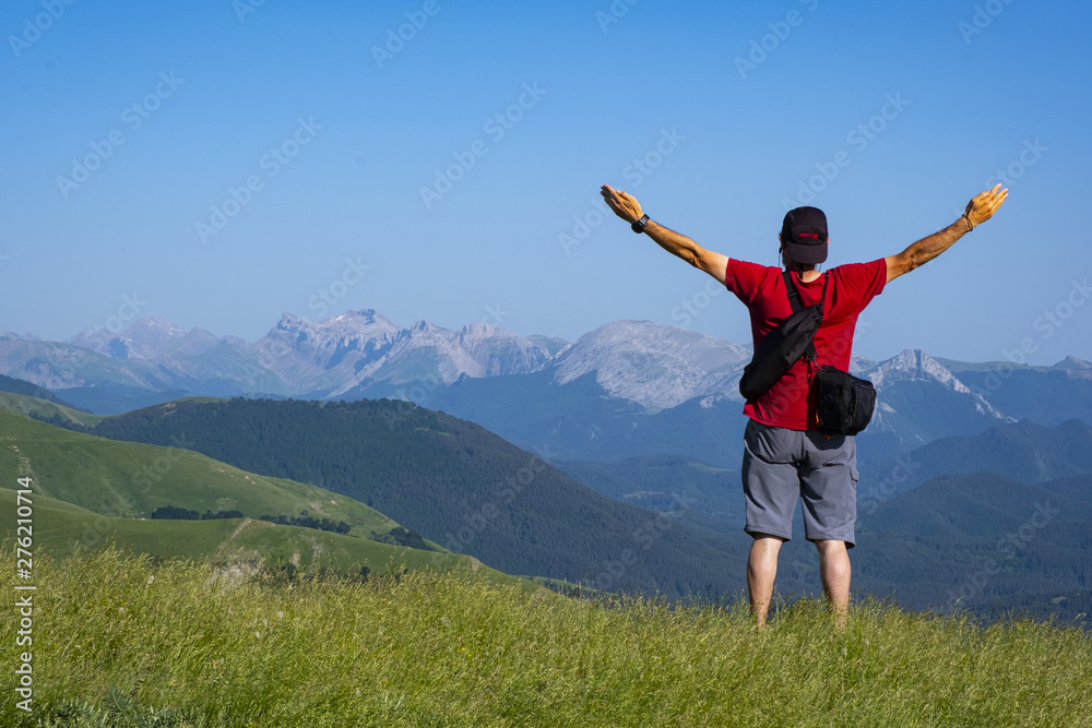 man with arms raised on top of the mountain, mountain range of the Pyrenees man with arms raised on top of the mountain, mountain range of the Pyrenees