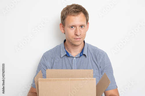 A young handsome caucasian man holding an open cardboard box in his hands and smiled