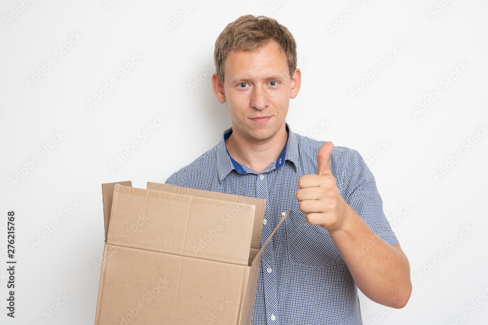 curious man looking inside a cardboard box he holds in his hands on a white background curious man looking inside a cardboard box he holds in his hands on a white background