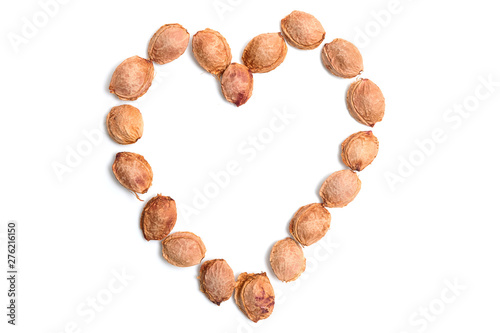 The bones of the apricot on a white isolated background in the form of a heart
