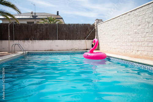 Inflatable flamingo alone in a pool without people a summer day