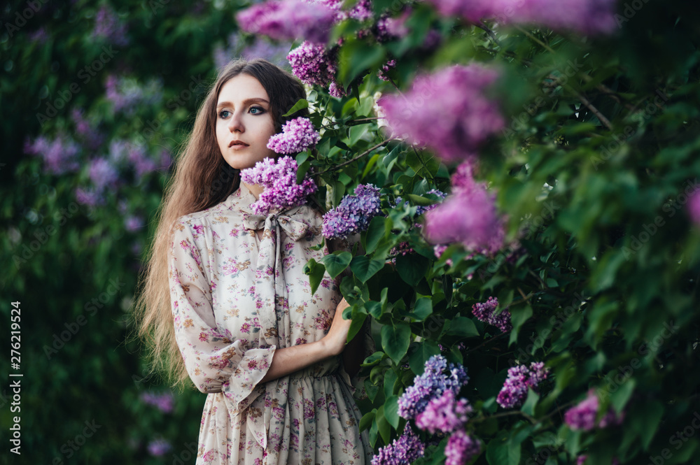 Beautiful big-eyed girl near the lilac tree. Beautiful big-eyed girl near the lilac tree.