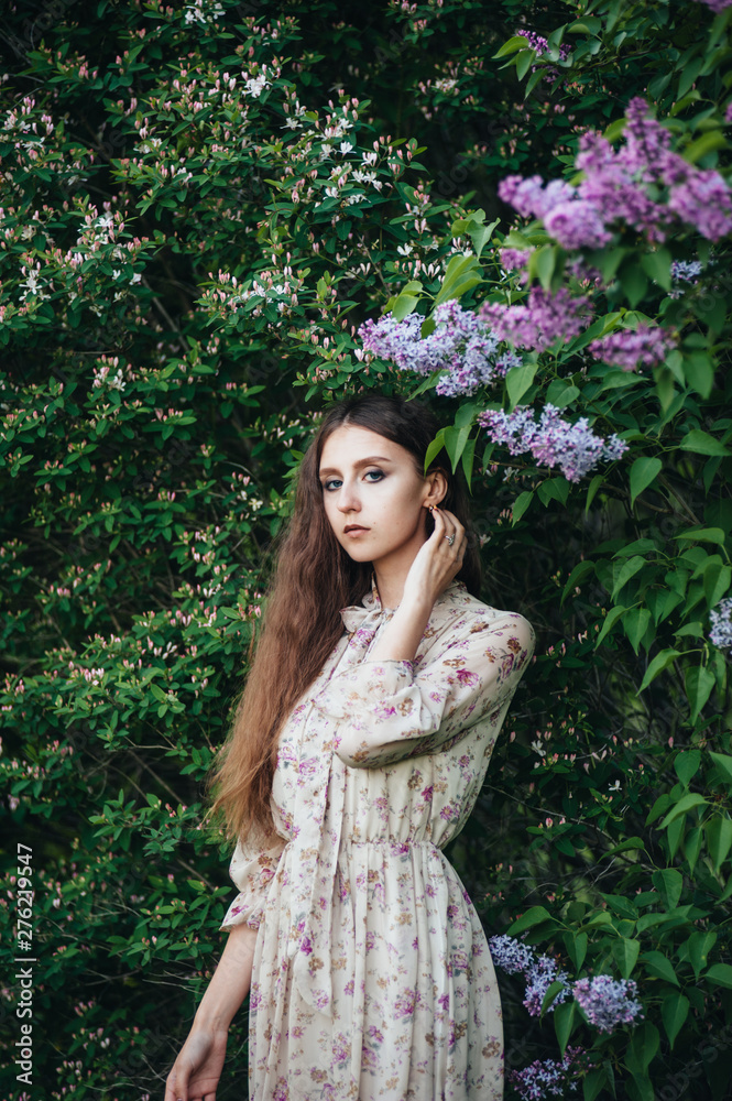 Beautiful big-eyed girl near the lilac tree. Beautiful big-eyed girl near the lilac tree.