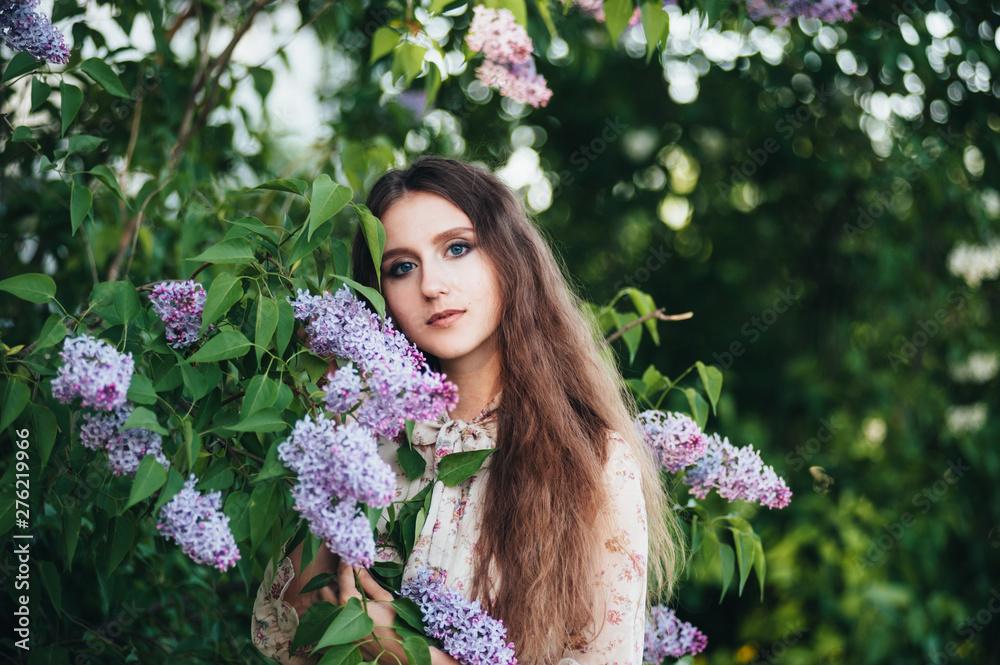 Beautiful big-eyed girl near the lilac tree. Beautiful big-eyed girl near the lilac tree.