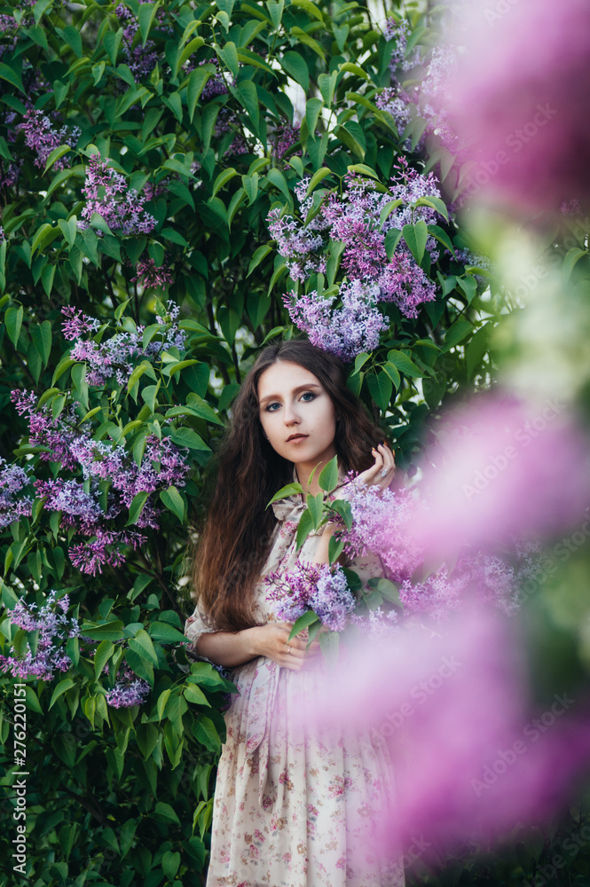 Beautiful big-eyed girl near the lilac tree. Beautiful big-eyed girl near the lilac tree.