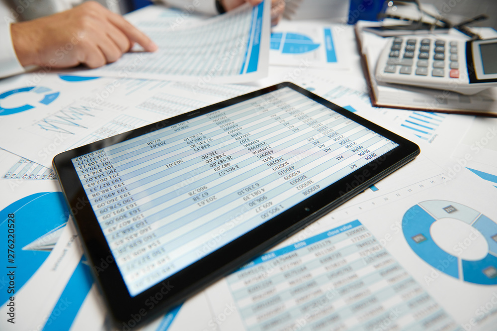 Businessman working and calculating, reads and writes reports. Using tablet pc. Office employee, table closeup. Business financial accounting concept. Businessman working and calculating, reads and writes reports. Using tablet pc. Office employee, table closeup. Business financial accounting concept.