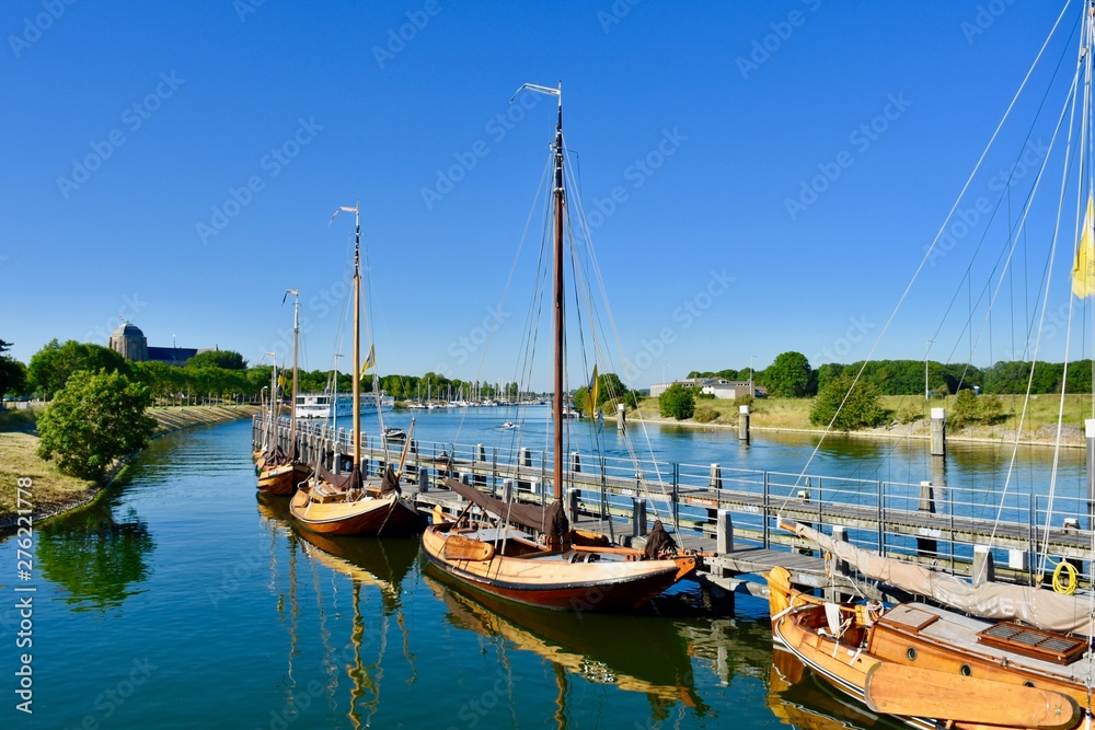 Serie of beautiful old wooden sailboats near lock in Veere, Zeeland, Netherlands