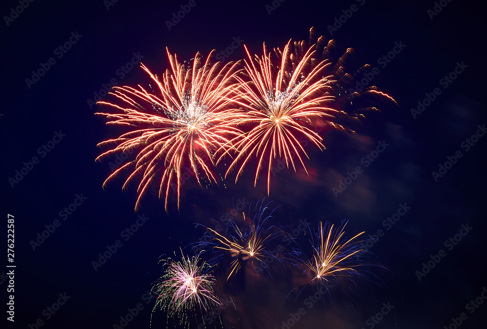 A few volleys of festive fireworks in the night sky, red-yellow