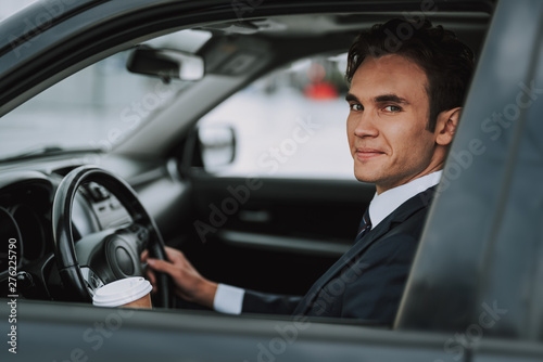 Happy man sitting behind wheel of car