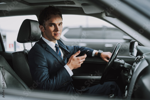 Young handsome man holding mobile phone in his car © Yakobchuk Olena