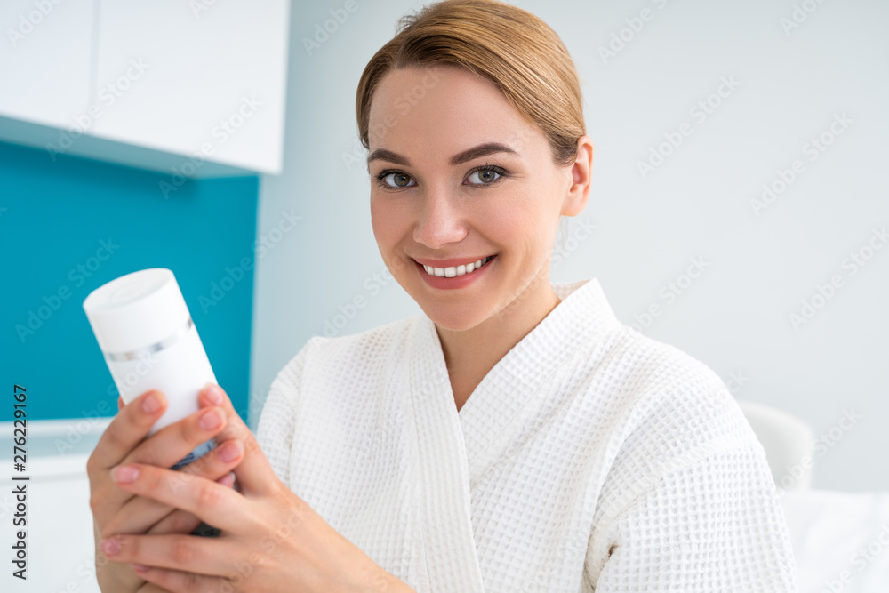 Close up of smiling woman with new cream in her hands Close up of smiling woman with new cream in her hands