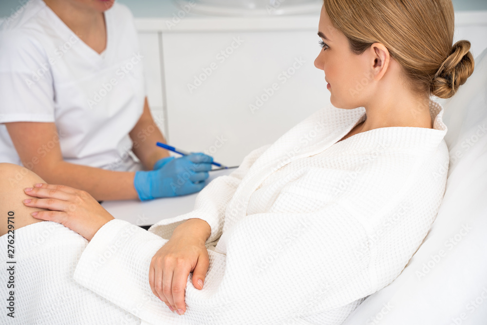 Obraz premium Doctor making notes and female client looking at it