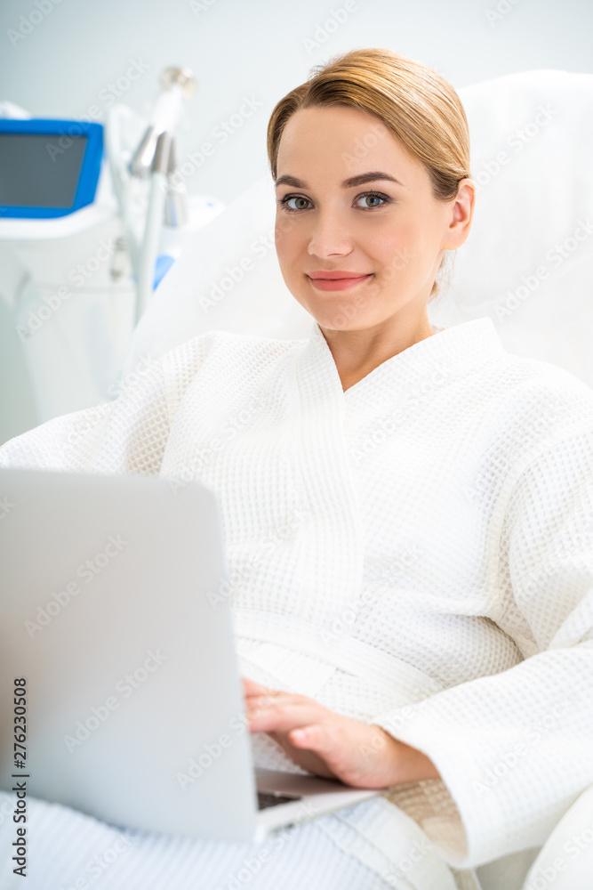 Caucasian beautiful woman situating in cosmetology office and using computer Caucasian beautiful woman situating in cosmetology office and using computer