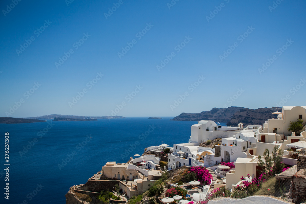 Oia town on Santorini island, Greece. View of traditional white houses and churches with blue domes over the Caldera