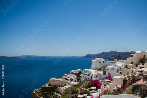 Oia town on Santorini island, Greece. View of traditional white houses and churches with blue domes over the Caldera