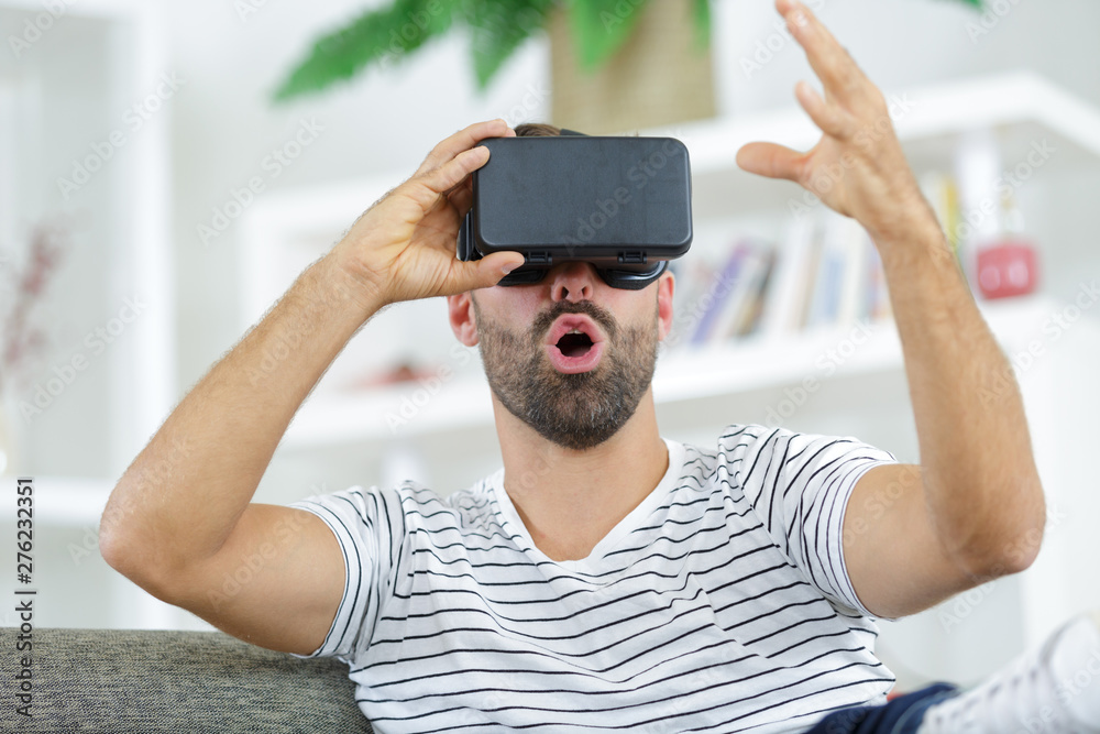 Naklejka premium man wearing vr headset and experiencing virtual reality