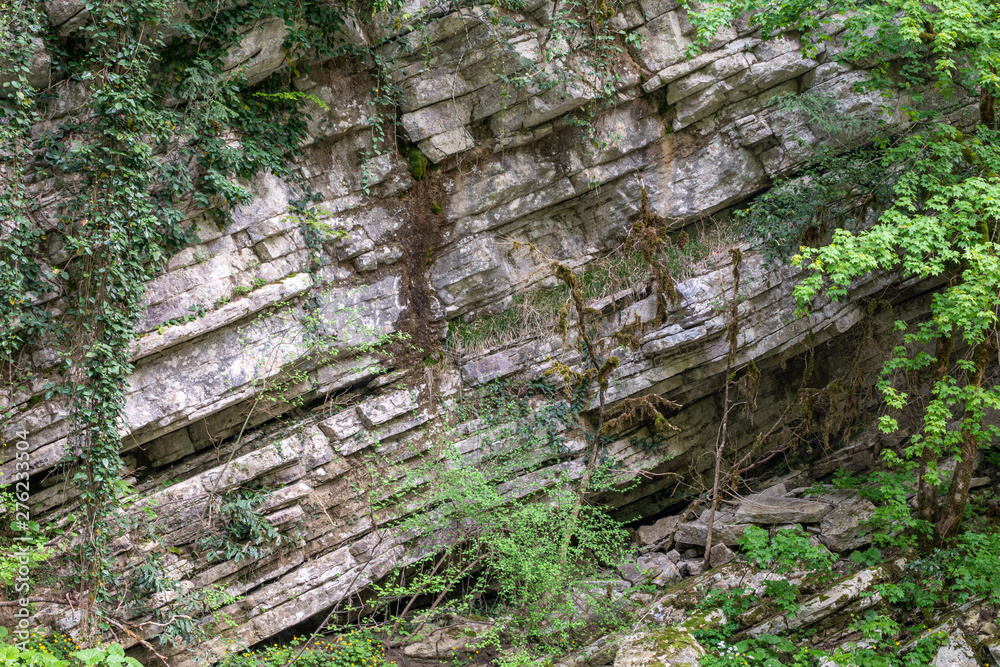 Rock of layered stone overgrown with grass and moss. Rock of layered stone overgrown with grass and moss.