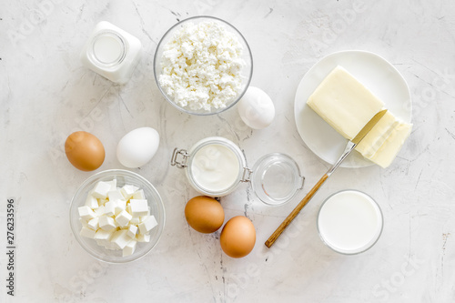 Fresh dairy products for breakfast with milk, cottage, eggs, butter, yougurt on white marble background top view mock up