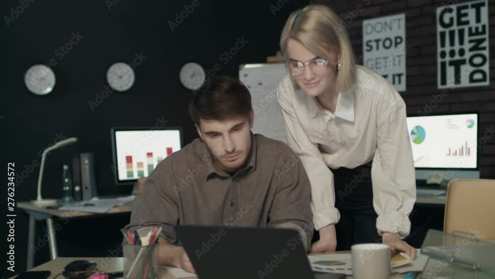 Satisfied woman boss praising employee for good work in dark office