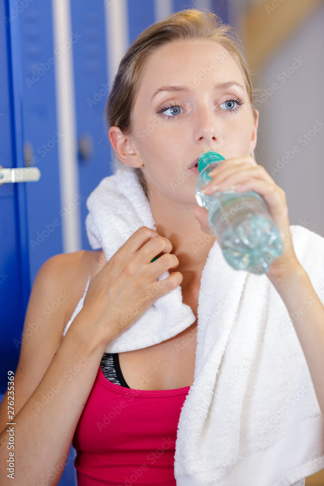 beautiful young woman resting and drinking water in the gym beautiful young woman resting and drinking water in the gym
