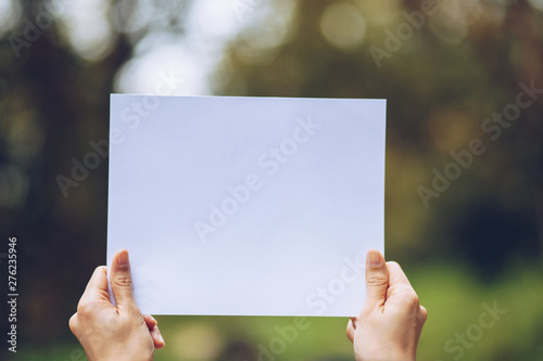 Show business paper in hand on nature background © khonkangrua