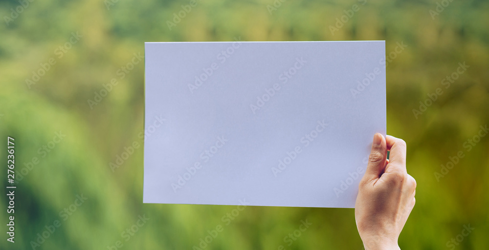Show business paper in hand on nature background Show business paper in hand on nature background