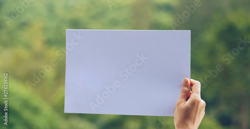 Show business paper in hand on nature background