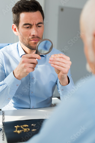 jeweler looking through a magnifier to check a ruby