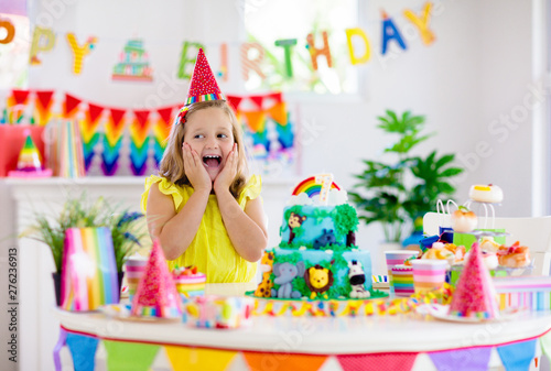 Photography Child birthday party. Kids blow candle on cake.