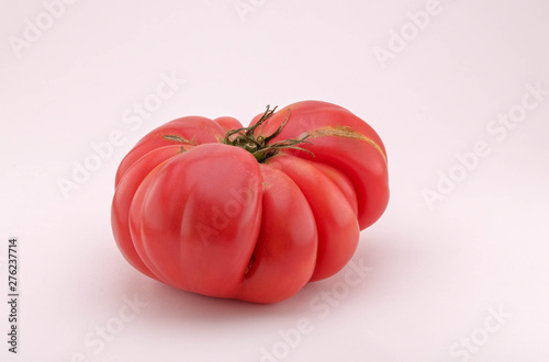 Close up on the big fresh tomato.  Ripe juicy tomato isolated on white background. Vegetables from the farmers market. Eco products. Vitamins vegetarian diet. Healthy food.
