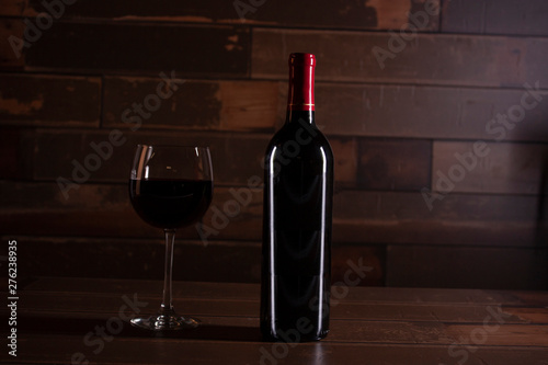 Luxurious scene enters bottle wood with red wine next to a glass served in Mexico