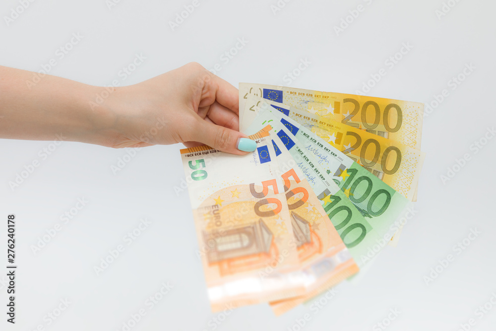 Female hands holding euro banknotes on a white background. Female hands holding euro banknotes on a white background.