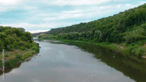 Beautiful aerial 4k view over the curving river along the fields and forest photo