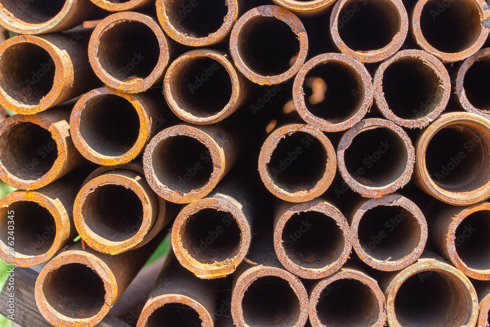 Metal pipes made of iron with traces of rust, building materials, the background texture is horizontal. Round rusty ends Metal pipes made of iron with traces of rust, building materials, the background texture is horizontal. Round rusty ends