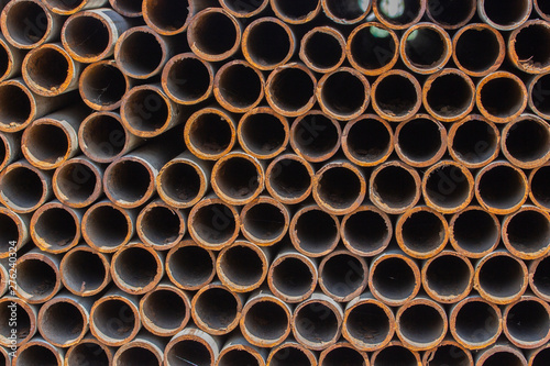 Rusty metal iron pipes  background texture. A pile of metal pipes end view  round rusty sections of iron structures  building material