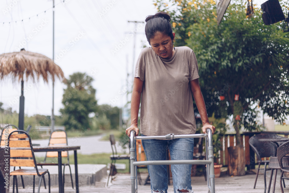 Young women using a walker cane during rehabilitation,medical and orthopedic concept,Healthcare and medical concept Young women using a walker cane during rehabilitation,medical and orthopedic concept,Healthcare and medical concept