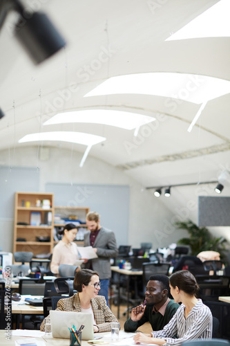 Wide angle view at multi-ethnic group of people working in office, copy space