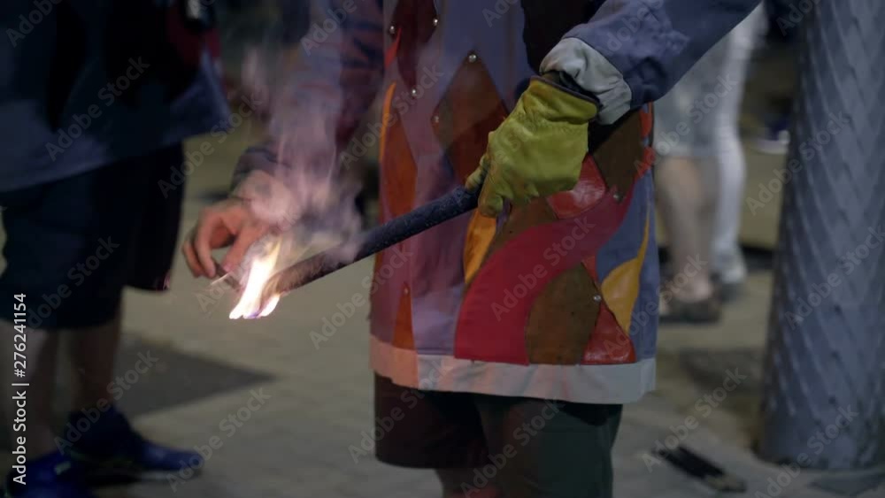 A man fires big firework during San Juan celebration in Barcelona. Flame in a hand, with a glove protection A man fires big firework during San Juan celebration in Barcelona. Flame in a hand, with a glove protection