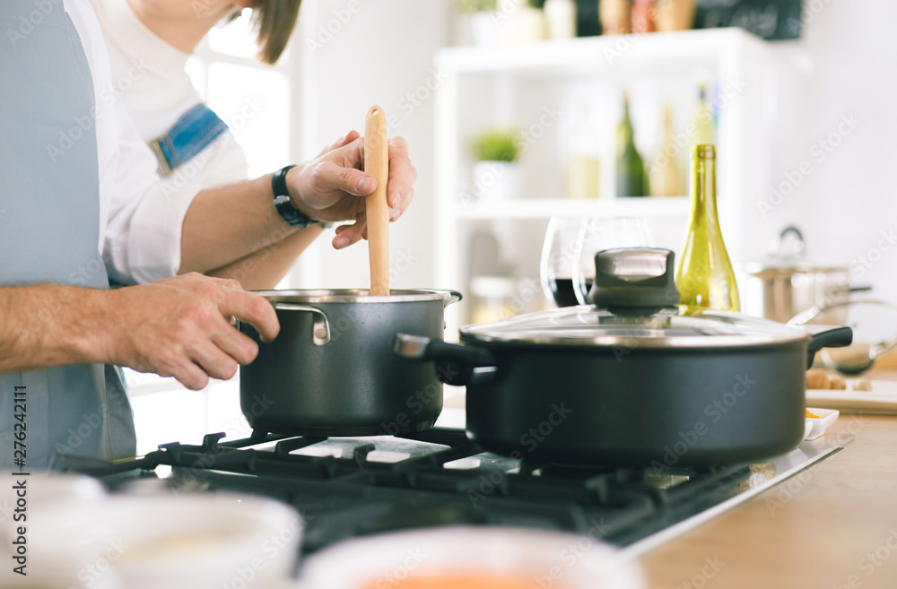 Couple cooking together in the kitchen at home Couple cooking together in the kitchen at home