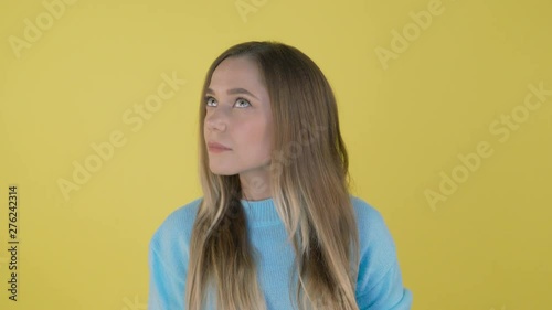 Young beautiful woman casual blue sweater over isolated background smelling something stinky and disgusting, intolerable smell, holding breath with fingers on nose. Bad smells concept 4K