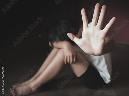 Young girl sitting on the floor with showing stop hand for stop violence and rape,