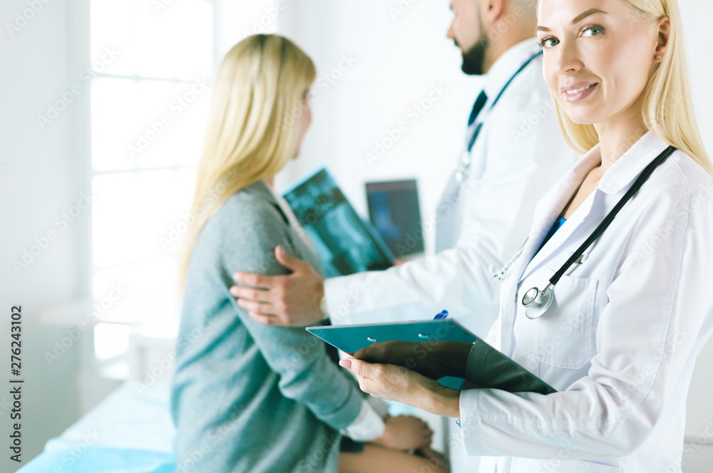 Handsome male doctor consulting a couple about infertility in his medical office Handsome male doctor consulting a couple about infertility in his medical office