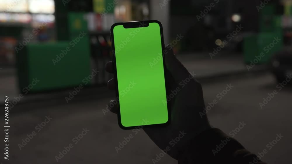Hands holding use smartphone with vertical green screen on night city colorful light background gas station car communication device hands digital gadget phone touchscreen mobile slow motion Hands holding use smartphone with vertical green screen on night city colorful light background gas station car communication device hands digital gadget phone touchscreen mobile slow motion