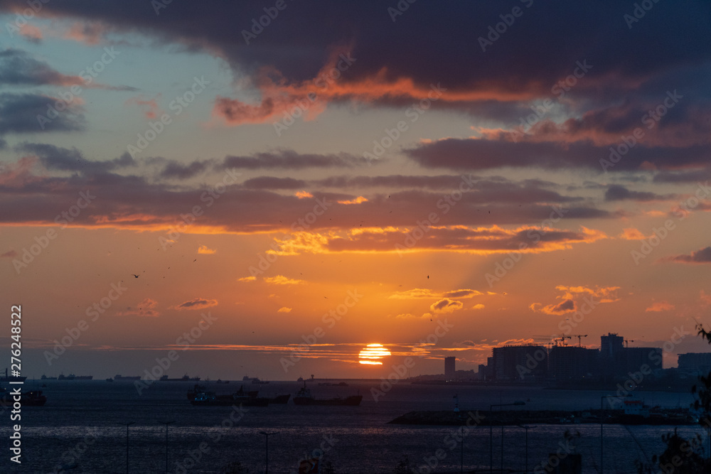 Fototapeta premium Sunset Over the Sea with Ship Silhouettes