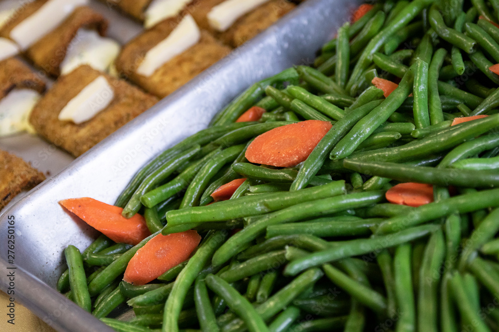 Green beans and carrots being prepared in large quantity